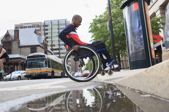 A man on the wheelchair passing the street